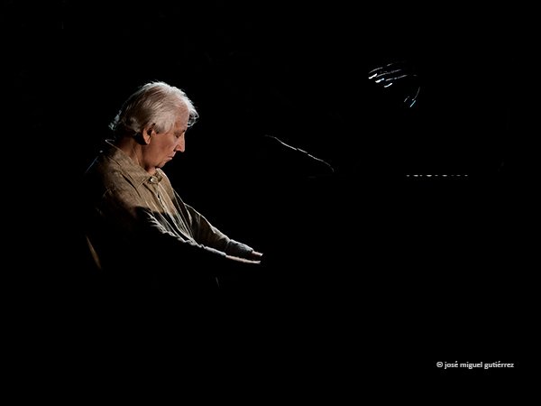 Wim Mertens al piano ligeramente echado hacia atrás con los ojos cerrados, en una imagen cargada de sentimiento.
