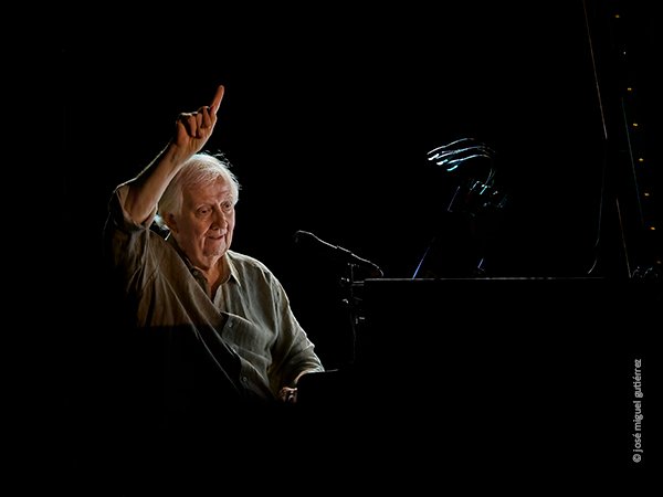 El músico belga Wim Mertens hace uno de sus gestos más significativos levantando la mano derecha y señalando con su dedo índice.
