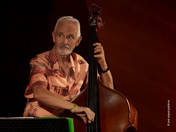 Al contrabajo Baldo Martínez dirige a su grupo. Plano medio largo con la mirada muy visible, dirigida hacia la derecha en gesto concentrado.